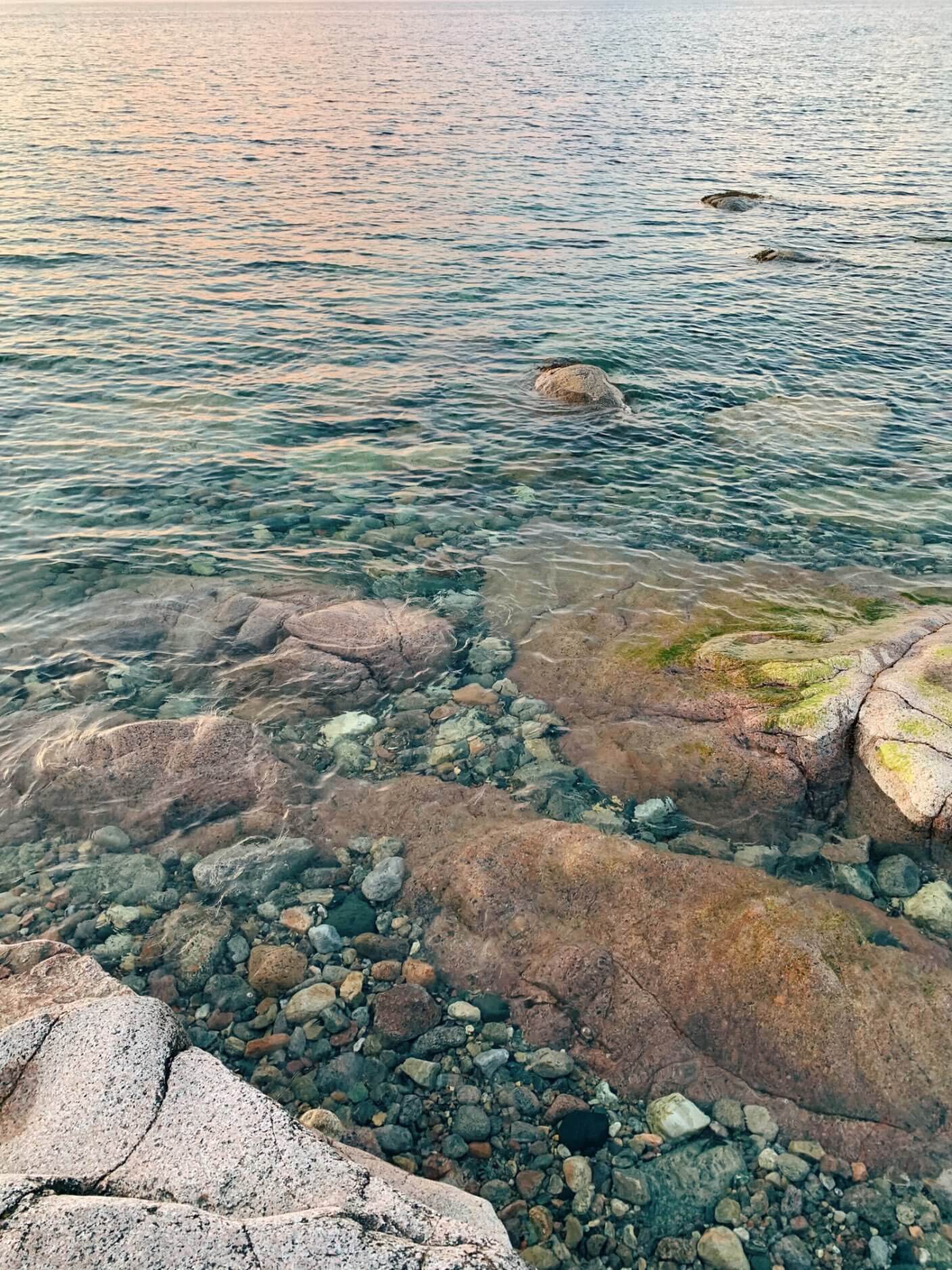 Sun setting over still, peaceful water